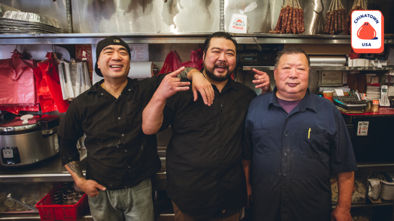 Three butchers standing in front of Hing Lung restaurant