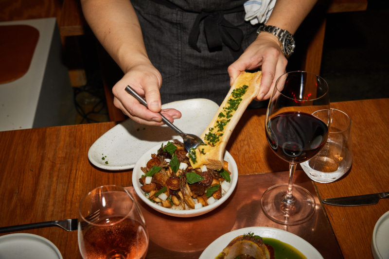 A server scoops bone marrow into a dish at LittleMad.
