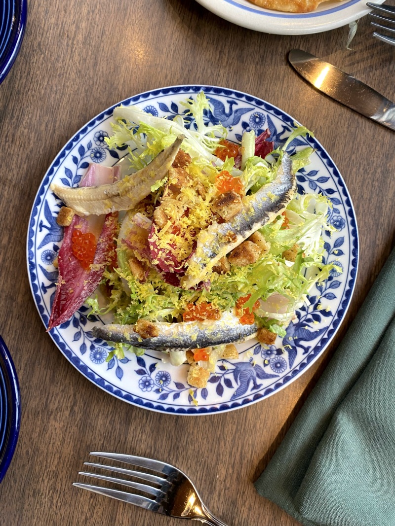 The chicories Caesar salad features boquerones, cured egg yolk, and trout roe.