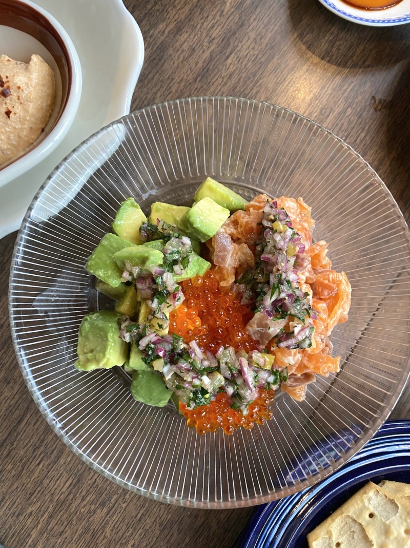 The house smoked salmon dip from the Snack Time menu features Seasoned avocado, Kewpie mayonnaise, Aleppo pepper, and trout roe served with tam tams.