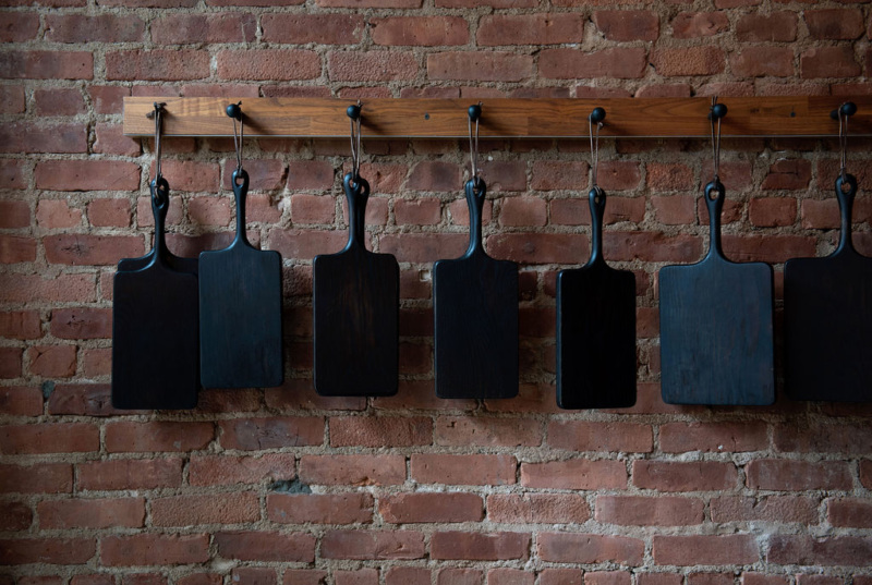 Black wooden cutting boards lining the wall of the restaurant are made from a master wood artist from upstate New York.