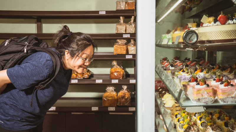Immigration lawyer, restaurant owner, and community activist Debbie Chen peers into the dessert display at Six Ping Bakery in Houston's Asiatown.