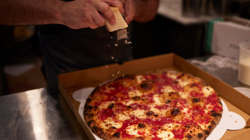 Putting the finishing touches on a pizza at Brooklyn DOP