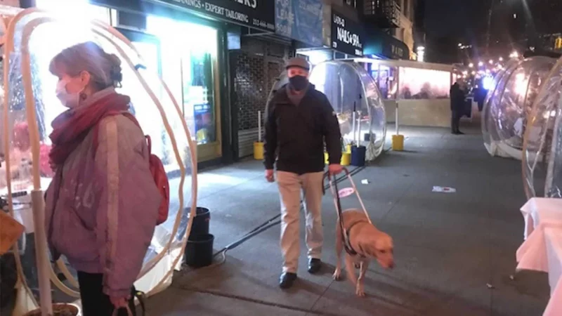 Peter Slatin and his guide dog on the sidewalk in New York City