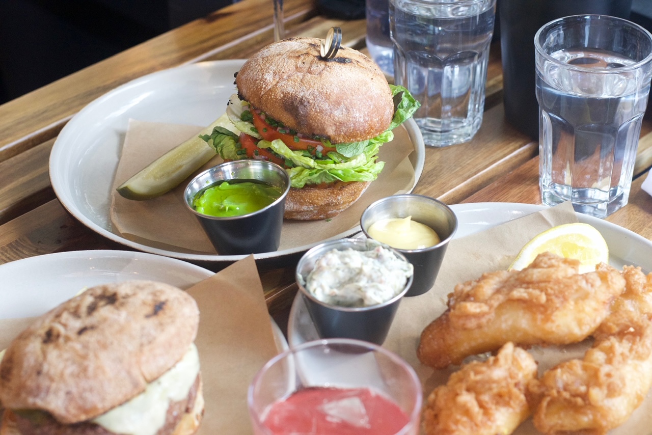 Clockwise from top left: the tomato burger; beer-battered fluke; and the cheddar pickle burger