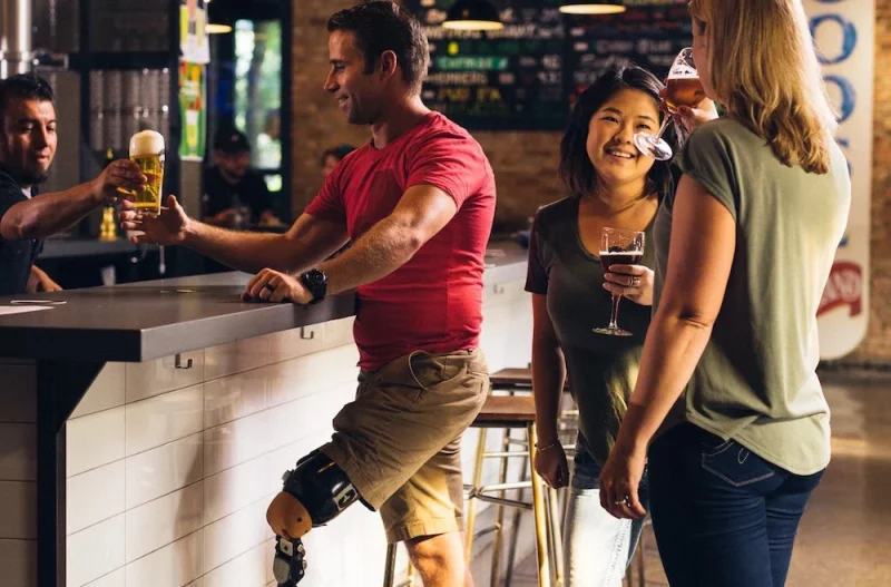 Man with prosthetic leg standing at bar