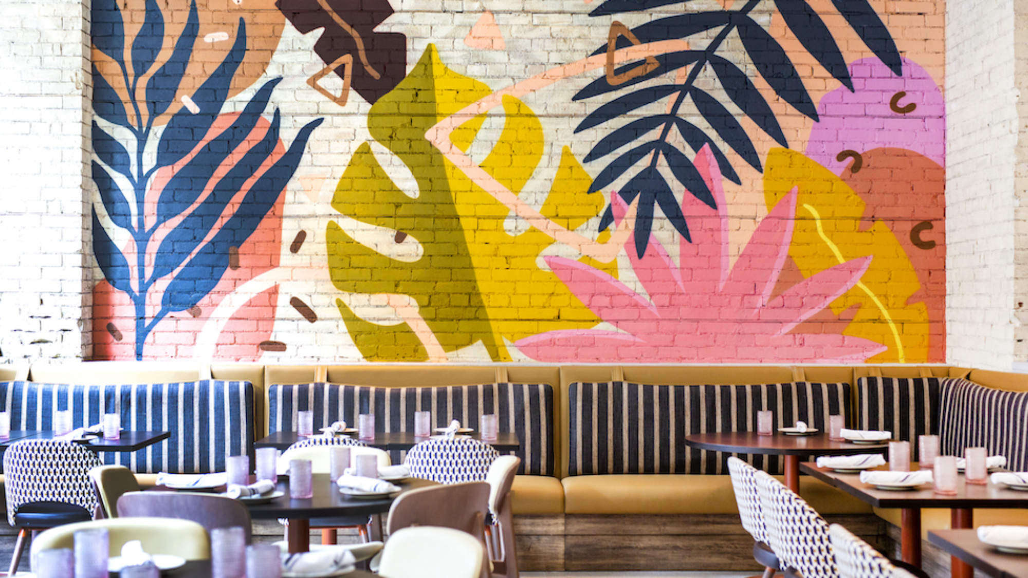 Colorful walls with painted leaves inside Planta Cocina in Toronto