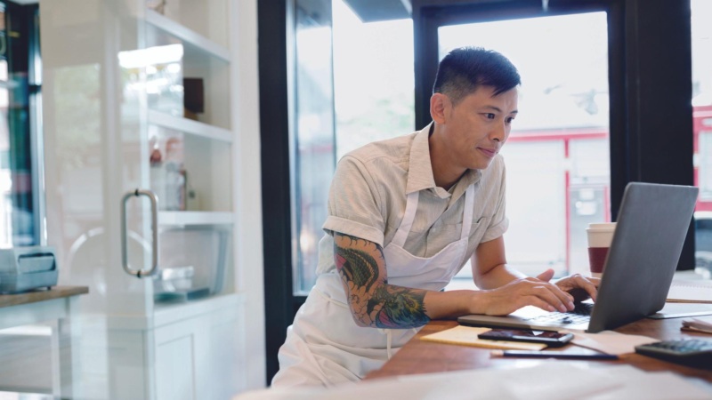 Bakery business owner working at laptop