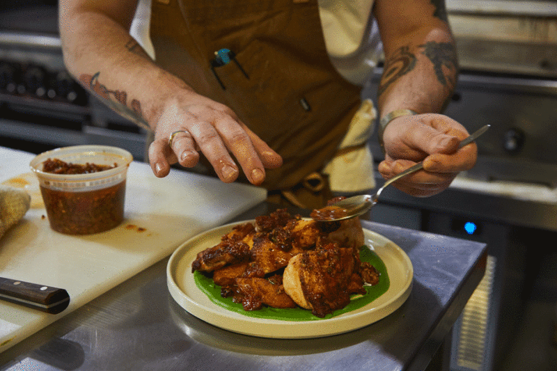 Chef Henzy puts the final touches on the brick chicken.