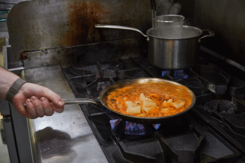 Chef Sam Henzy cooks the rigatoni on the stove.