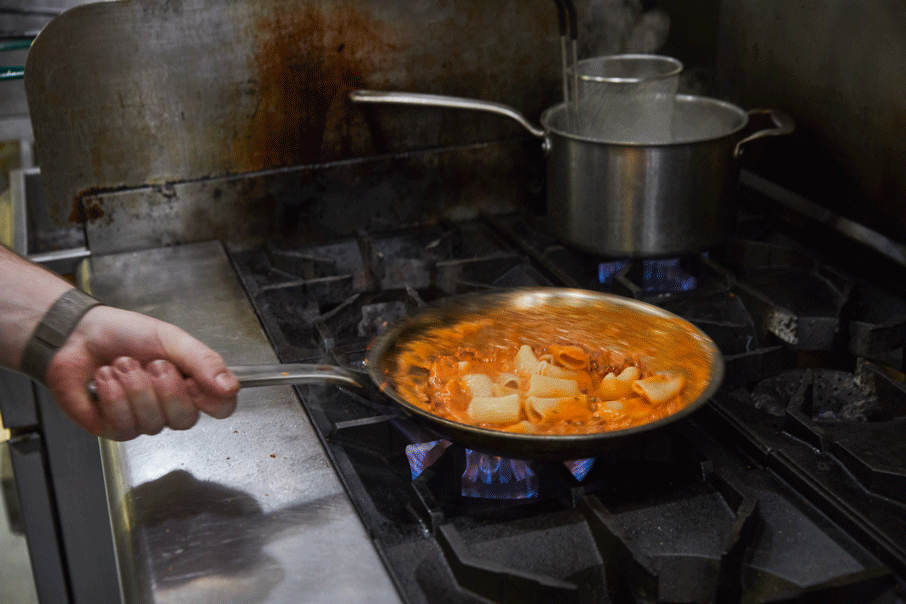 Chef Sam Henzy cooks the rigatoni on the stove.