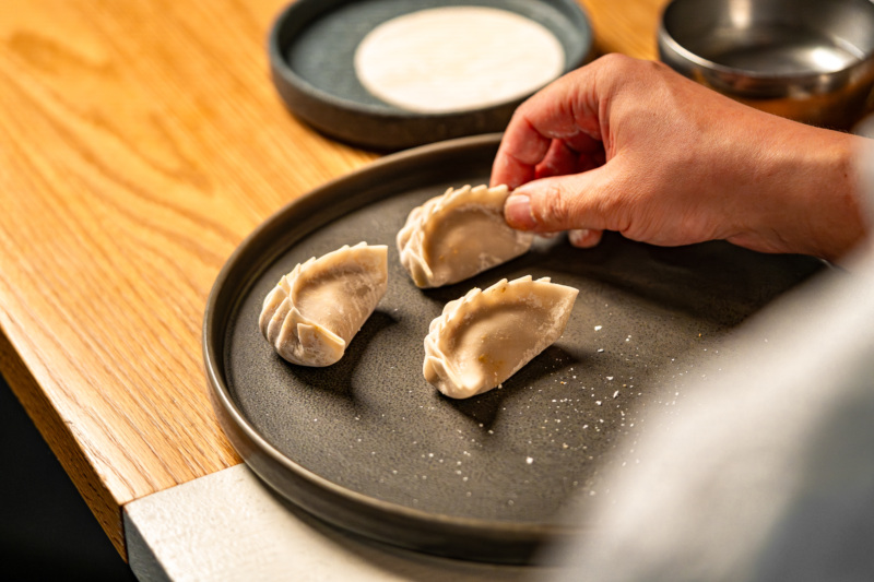 Folding the pork and kimchi mandu