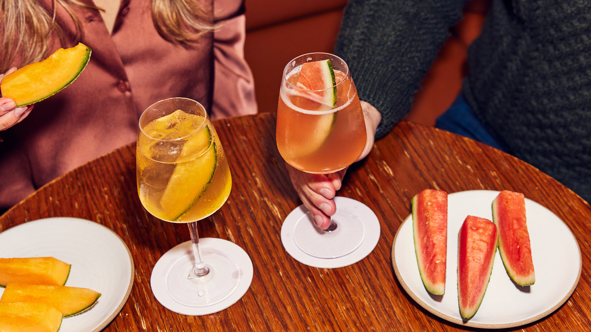 Mocktail spritzes with accompanying fruit on a table