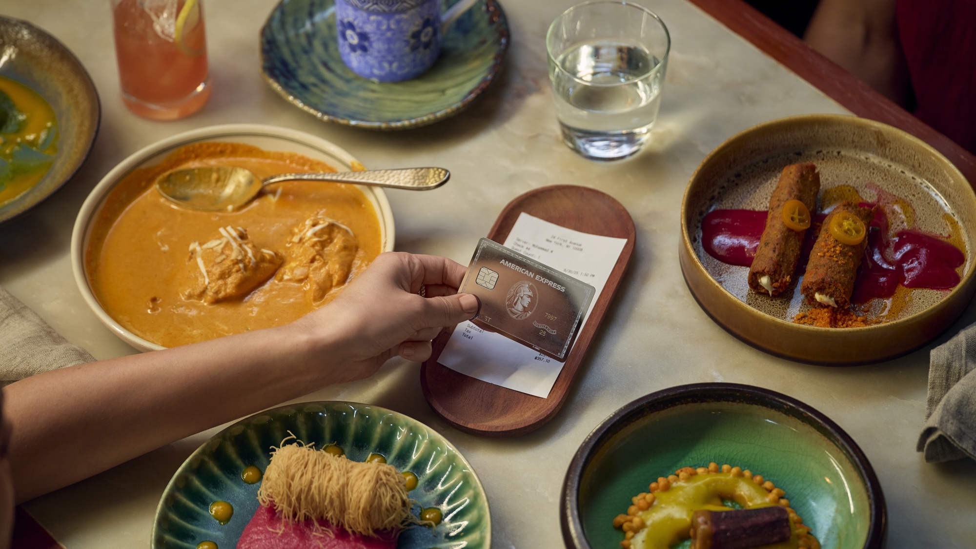 A diner pays a restaurant bill with their American Express Platinum Card