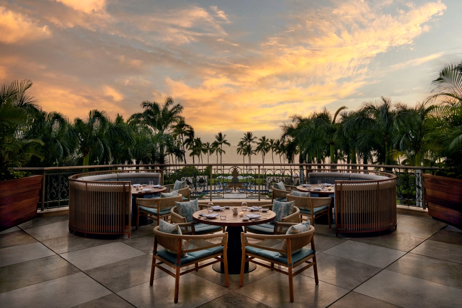 outdoor restaurant patio seating with sunset view and palms trees