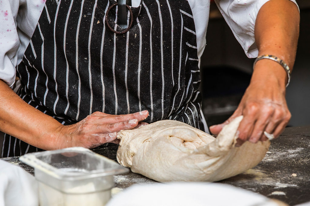 person kneading dough