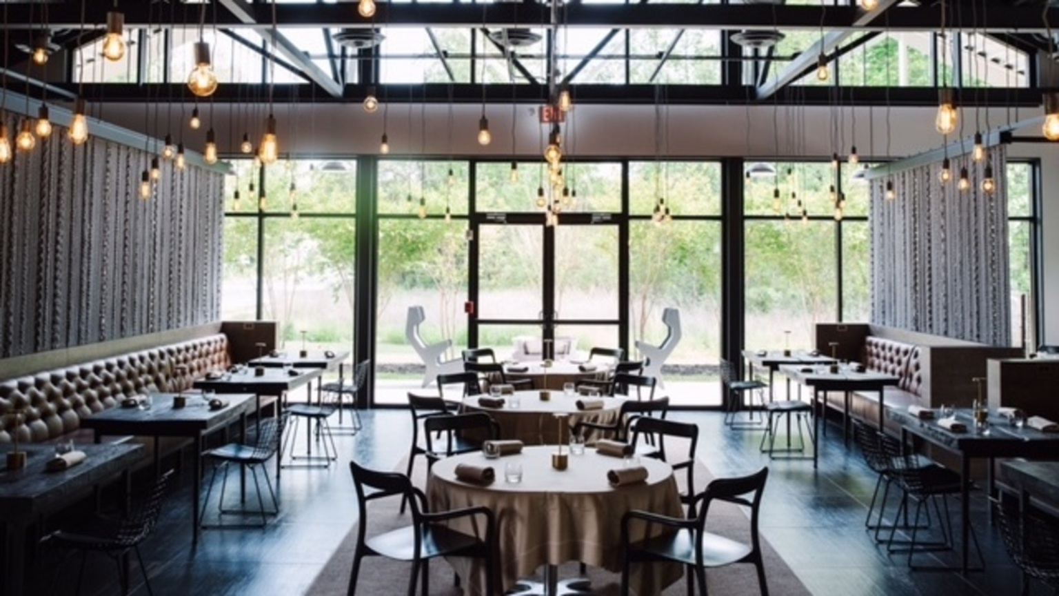 empty restaurant with floor to ceiling windows and industrial lighting