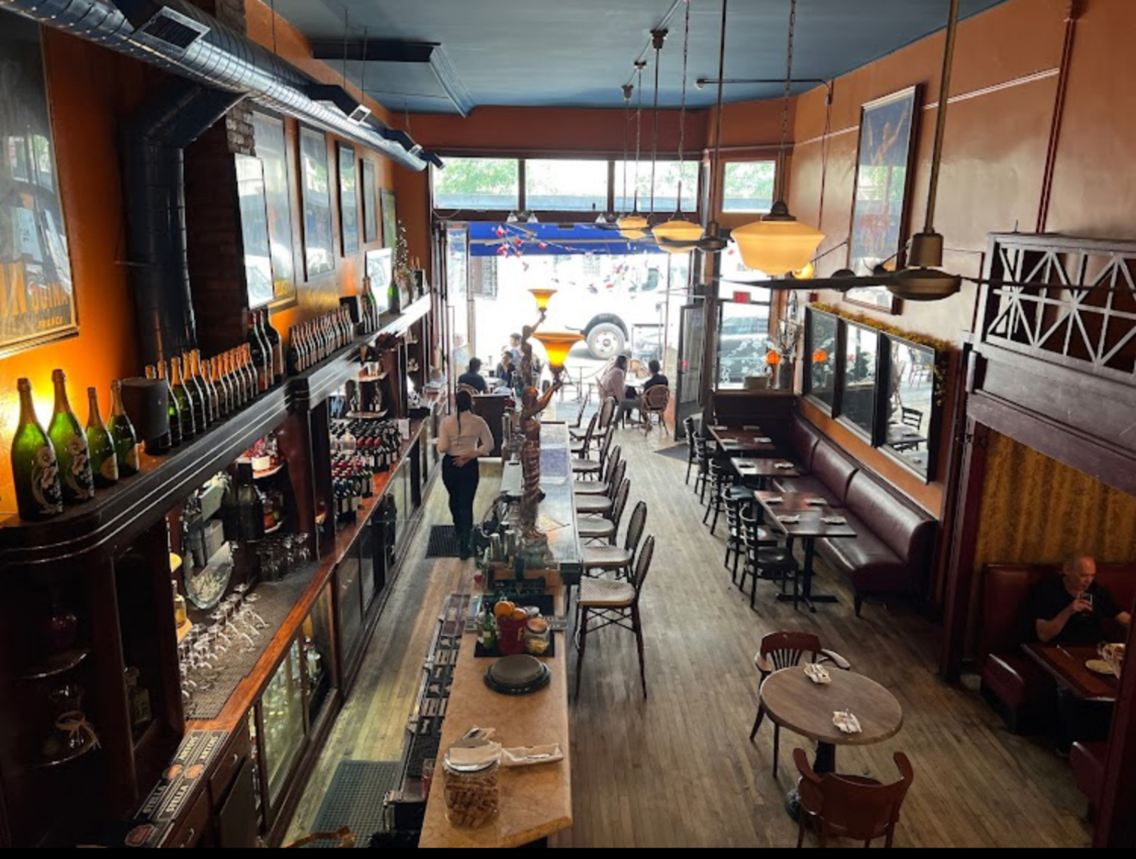 Caribou Cafe bar interior with server walking towards diners dining al fresco