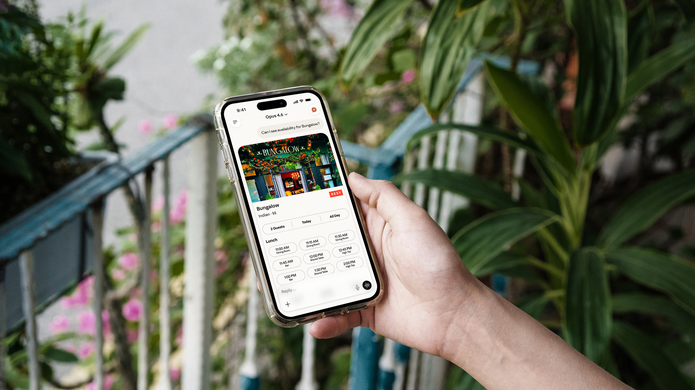 A hand holding an iPhone displays availability for a Resy restaurant in the Claude app