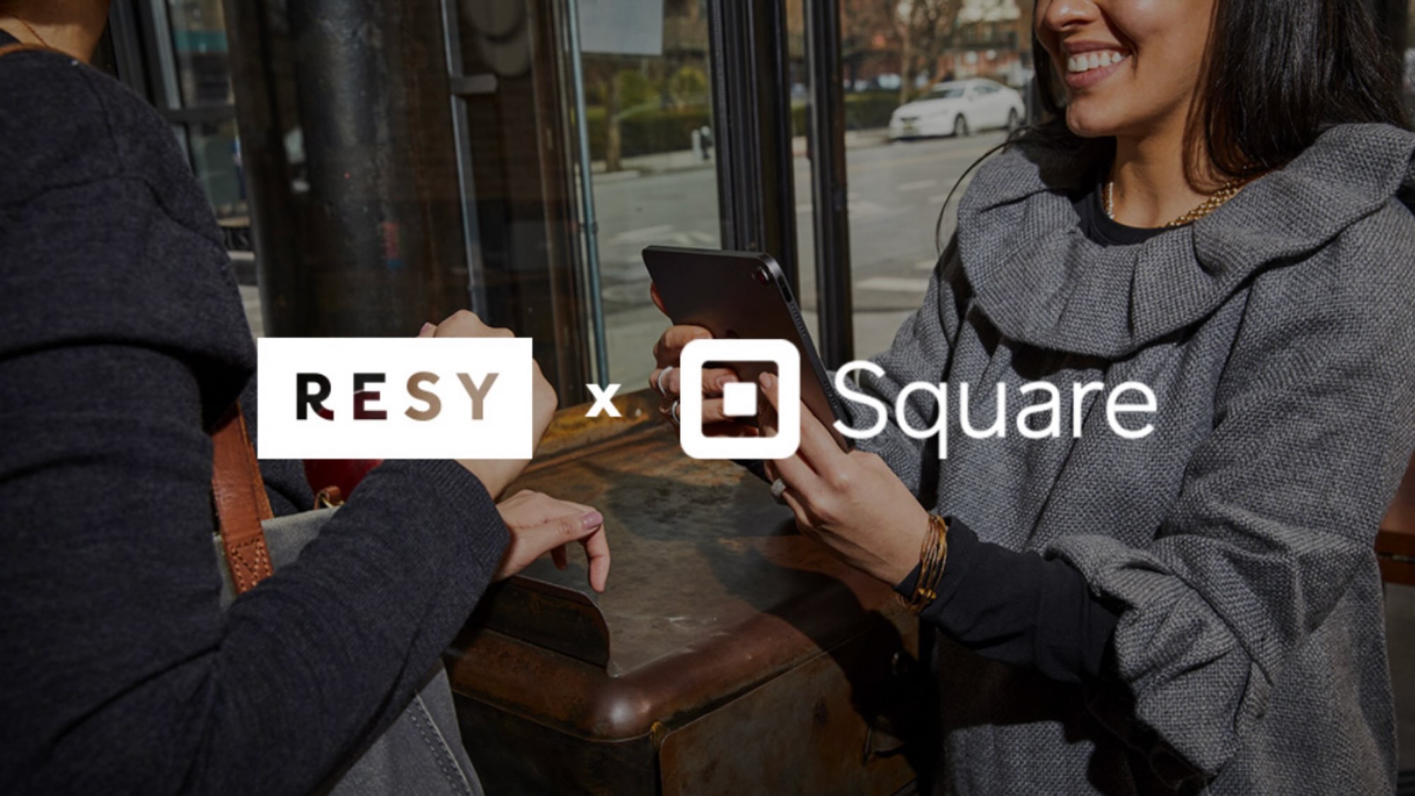 girl on tablet at host stand with a customer and Resy + Square logos on top of the time