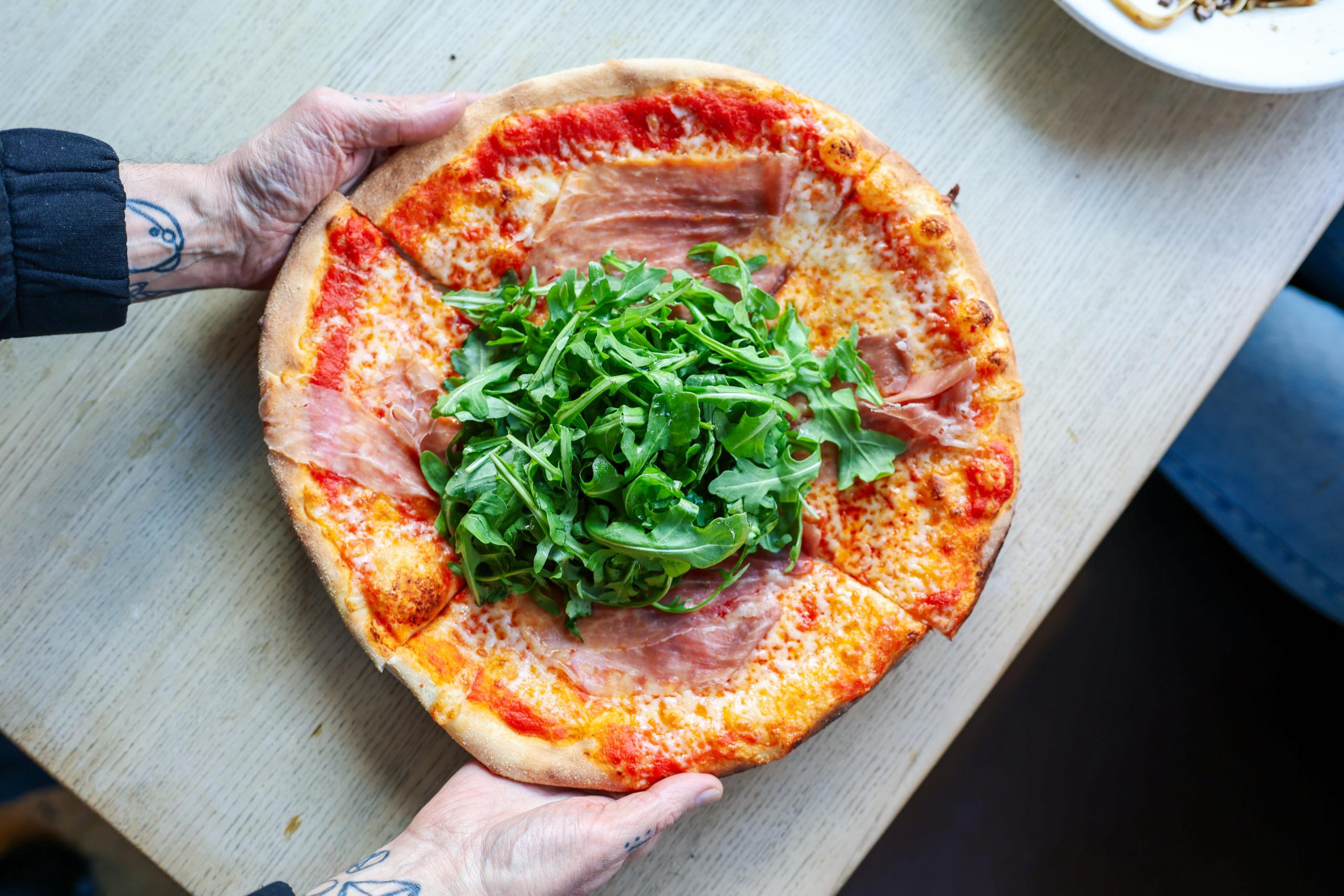 person holding a pizza with two hands