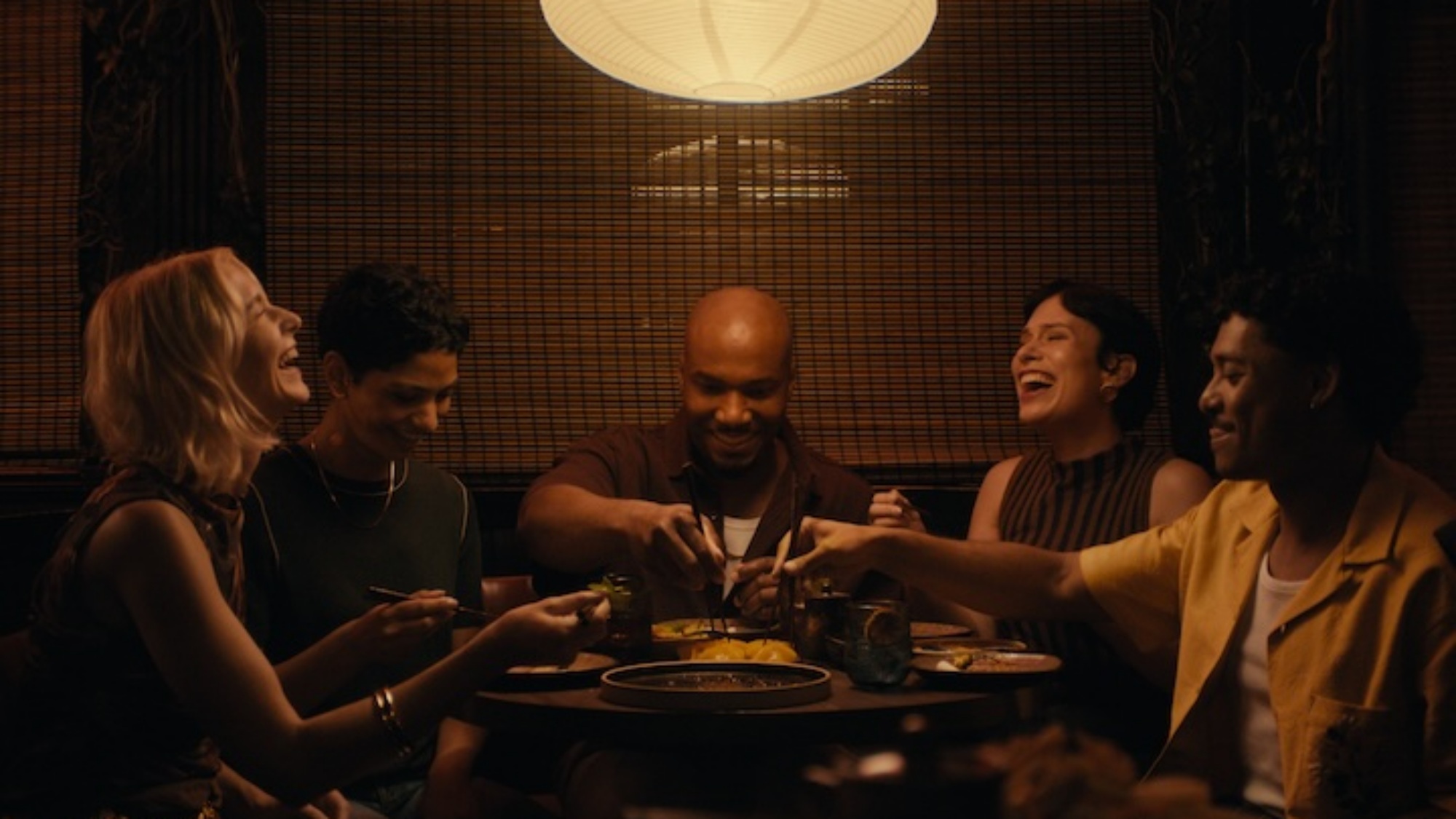 People sitting around a round dinner table sharing a meal.