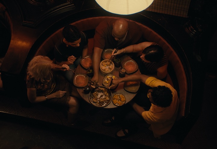 Overhead view of people dining at a table and sharing food