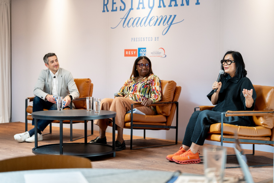 A man and two women speaking on a panel.
